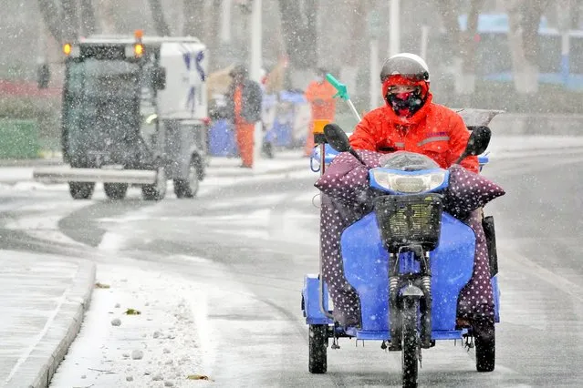 A man rides a tricycle during snowfall in Yantai in China's eastern Shandong province on November 30, 2022. (Photo by AFP Photo/China Stringer Network)