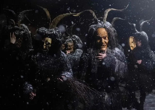 Revellers wearing devil masks and black sheepskin representing Krampus, the helper of Saint Nicholas, attend the Saint Nicholas parade (Nikolospiel) at Bad Mitterndorf, Styria, Austria on December 5, 2022. This traditional performance, that has been passed on orally, takes place every December 5 and was added in 2020 on the list of the UNESCO Austria intangible cultural heritage. (Photo by Joe Klamar/AFP Photo)