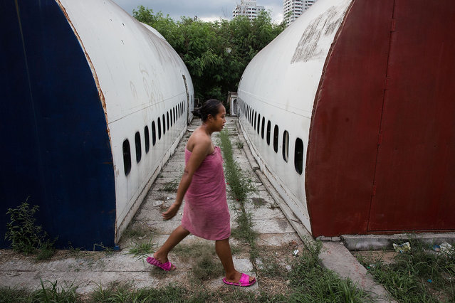A Thai woman returns to her home in a disused airplane section after washing on September 12, 2015 in Bangkok, Thailand. (Photo by Taylor Weidman/Getty Images)