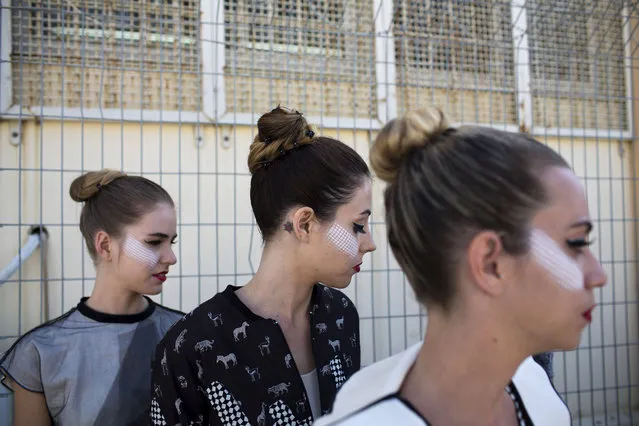 In this Monday, October 27, 2014 photo, models wait in line before walking the runway for a fashion show in Neve Tirza prison in Ramle, central Israel. (Photo by Oded Balilty/AP Photo)