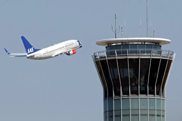 A Scandinavian SAS airline passenger plane flies near the air traffic control tower after taking off from Charles de Gaulle International Airport in Roissy, near Paris, August 21, 2013. (Photo by Charles Platiau/Reuters)