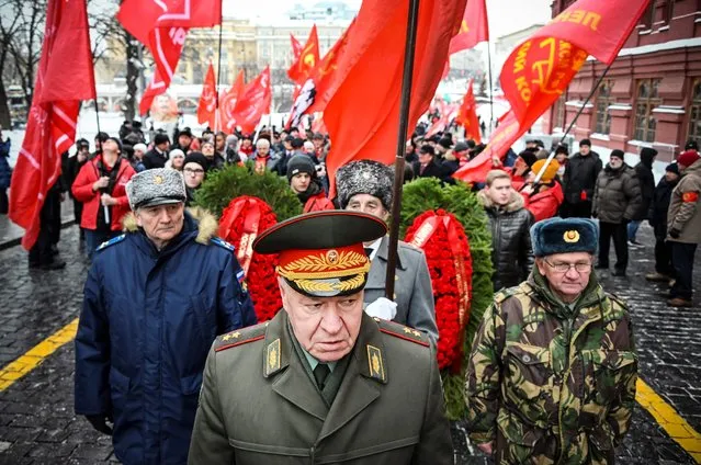 Russian Communist party supporters march to lay flowers to the tomb of late Soviet leader Joseph Stalin during a memorial ceremony to mark the 143-rd anniversary of his birth at Red Square in Moscow on December 22, 2020. While historians blame Stalin for the deaths of millions in purges, prison camps and forced collectivisation, many in Russia still praise him for leading the Soviet Union to victory over Nazi Germany in World War II. (Photo by Alexander Nemenov/AFP Photo)