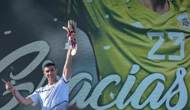 The goalkeeper of the Argentine soccer team Emiliano Martinez, holds gold medal and gold glove trophy awarded by FIFA during a tribute to him, in Mar del Plata, Argentina, on December 22, 2022, upon his return to his hometown after winning the Qatar 2022 World Cup tournament. (Photo by Mara Sosti/AFP Photo)