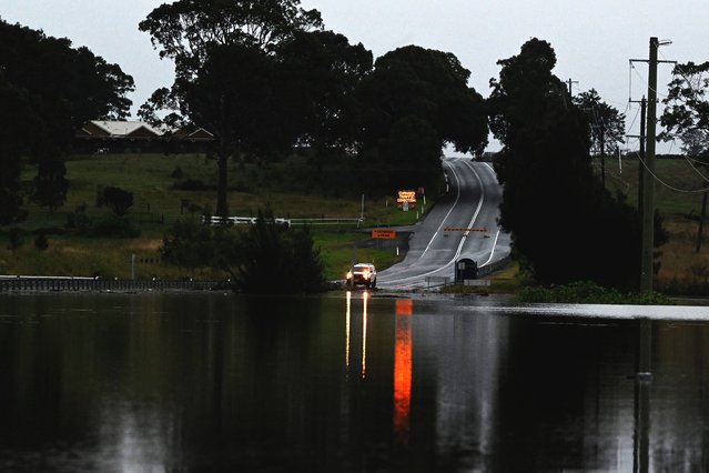 A road is seen flooded from the over flowing Wallis Creek in Gillieston Heights near New South Wales town of Maitland on May 22, 2025. Record floods cut a destructive path through eastern Australia on May 23, caking houses in silt, washing out roads and separating 50,000 people from help. (Photo by Saeed Khan/AFP Photo)