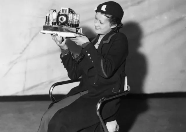 A woman at the opening of the Radio Exhibition at Olympia Exhibition Centre, west London, holds up the smallest radio in the show – an all mains electric, 4 valve Sunbeam Midget, priced at six pounds six shillings; 15th August 1933.  (Photo by J. A. Hampton/Topical Press Agency/Getty Images)