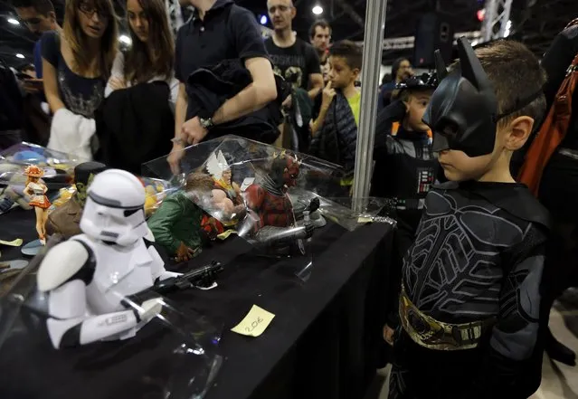A young participant dressed as superhero Batman looks at figurines during the first edition of the HeroFestival in Marseille, November 9, 2014. (Photo by Jean-Paul Pelissier/Reuters)