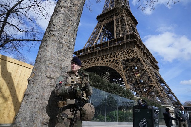 A soldier patrols at the Eiffel Tower, Monday, March 25, 2024 in Paris. France's government increased its security alert posture to the highest level Sunday March 24, 2024 after the deadly attack at a Russian concert hall and the Islamic State's claim of responsibility. (Photo by Michel Euler/AP Photo)