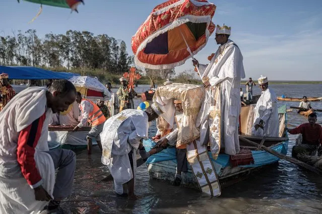High priests take off their shoes as they reach the shore with the ark of the covenant to celebrate timkat (Ethiopian Epiphany) on lake Batu, Ethiopia, on January 18, 2023. (Photo by Amanuel Sileshi/AFP Photo)