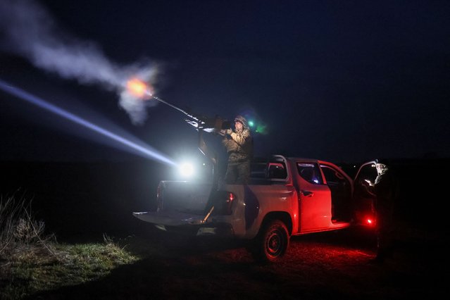 A Ukrainian serviceman from anti-drone mobile air defence unit fires a Browning machine gun at his position during combat, amid Russia's attack on Ukraine, in Chernihiv region, Ukraine on March 28, 2024. (Photo by Gleb Garanich/Reuters)