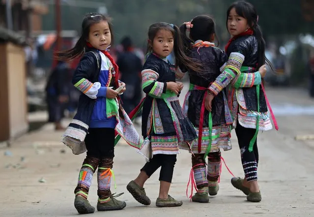 Ethnic Miao girls wearing traditional costumes look back on their way home after school at the village of Basha in Congjiang county, Guizhou province, November 27, 2014. The village, an ethnic Miao settlement with a population of 2,200, is believed to be the last community authorized by the Chinese government to keep guns. (Photo by Sheng Li/Reuters)