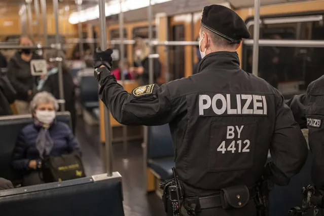 Police officers and an employee of VAG (Verkehrs-Aktiengesellschaft Nuernberg) in a subway train to control the mask requirement, to avoid the spread of the coronavirus, on the public transport service in Nuernberg, Germany, Friday, October 23, 2020. (Photo by Daniel Karmann/dpa via AP Photo)