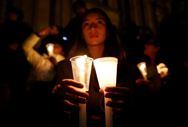 A supporter of the peace deal signed between the government and the Revolutionary Armed Forces of Colombia (FARC) rebels holds candles while attending a gathering at Bolivar Square during a “Silent March” in Bogota, Colombia, October 5, 2016. (Photo by John Vizcaino/Reuters)