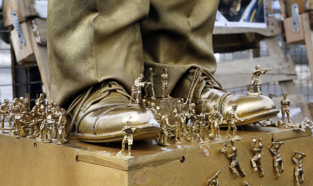 Th shoes of a figure depicting Russian President Vladimir Putin are photographed surrounded  by soldier figurines, in front of the Russian Embassy as right wing activists attempt to block access for Russian citizens who live in Ukraine to vote, in Kiev, Ukraine, Sunday, March 18, 2018. Security forces are surrounding Russian facilities in Ukraine amid anger over the Ukrainian government's refusal to allow ordinary Russians to vote for president. (Photo by Efrem Lukatsky/AP Photo)