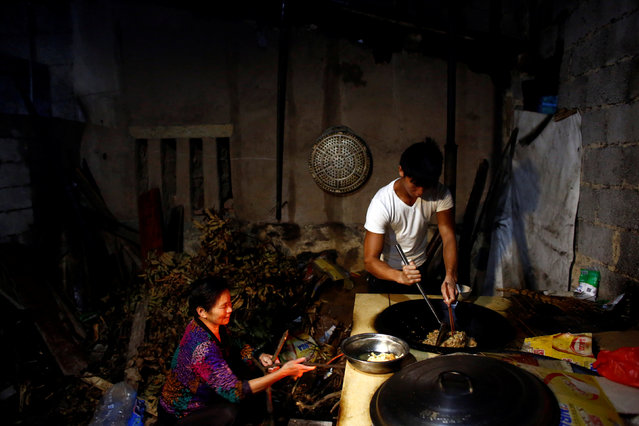 Worker Shi Shenwei (R) and his grandmother prepare breakfast in the kitchen of an old farm house that serves as dormitory for workers of a nearby construction site of a Buddhist temple in the village of Huangshan, near Quanzhou, Fujian Province, China, September 28, 2016. (Photo by Thomas Peter/Reuters)