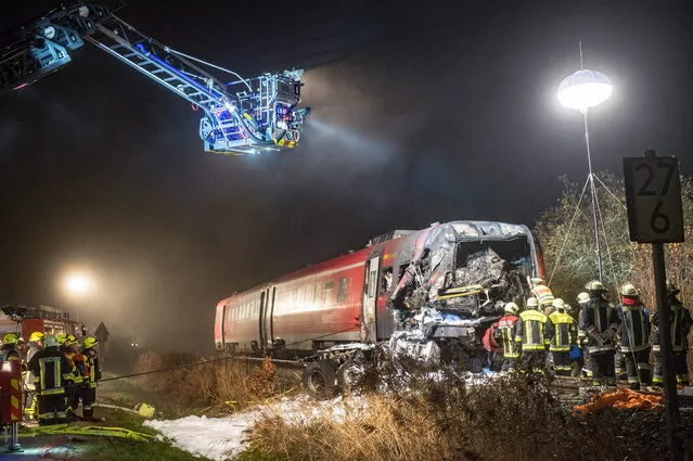 Emergency services  inspect a damaged train in Freihung, Germany, 05 November 2015. A passenger train struck a heavy lorry at a rail crossing late 05 November in southern Germany, leaving at least one person dead and multiple injured, police said. The lorry was believed to have stopped in the crossing before the collision, which was followed by an explosion. (Photo by Armin Weigel/EPA)