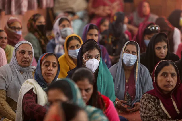 Sikh devotees, some of them wearing masks offer prayers during celebrations to mark the birth anniversary of the first Sikh Guru, Guru Nanak Dev, at a Gurudwara, or Sikh temple, in  Jammu, India, Monday, Novenver 30, 2020. India is second behind the U.S. in total coronavirus cases. Its recovery rate is nearing 94%. (Photo by Channi Anand/AP Photo)