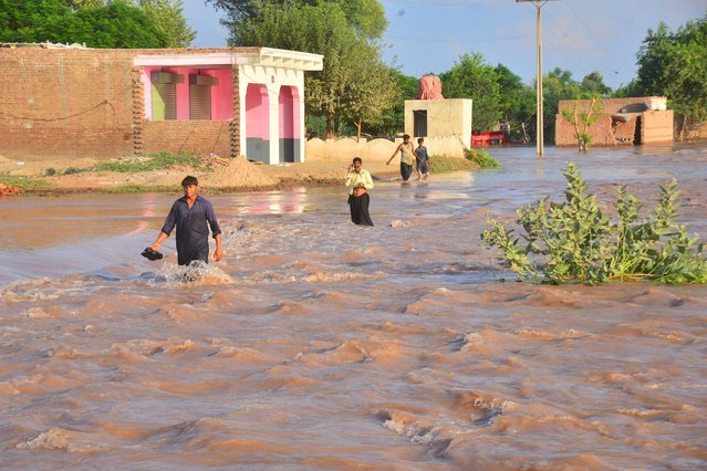 People cross a flooded area after rising flood waters in river Ravi, in Tandlianwala, Punjab province, Pakistan, 01 September 2025. At least 33 people have died and more than 1.4 million affected in Pakistan's Punjab province after heavy monsoon rains, melting glaciers and water releases from Indian dams caused three rivers to overflow, triggering severe flooding and 'exceptionally high' water levels, officials said. (Photo by Haji Ibraheem/EPA)