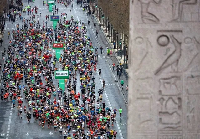 Runners compete on the Champs-Elysees avenue during the 46th edition of the Paris Marathon, 42,195 km, on April 2, 2023. The 42.195 km-route kicked off on the iconic Champs Elysees heading through the Bois de Vincennes park and along the Seine river, before looping around the Bois de Boulogne and ending near the Arc de Triomphe. (Photo by Franck Fife/AFP Photo)