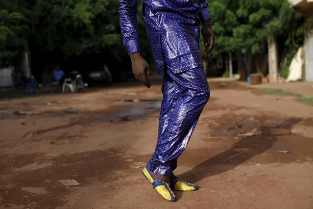 Bazin designer Baba Sereme poses for a picture in a bazin outfit he dyed, in front of his home in Bamako, Mali, October 8, 2015. (Photo by Joe Penney/Reuters)