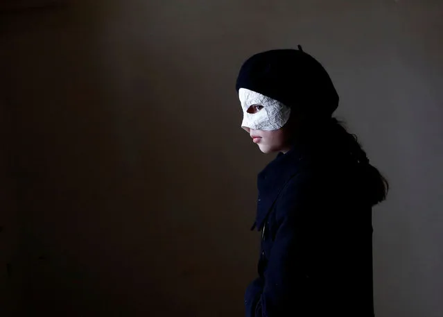 A child wearing a mask waits before marching through the streets during Easter celebrations in Ceske Budejovice, Czech Republic on April 7, 2023. (Photo by David W. Cerny/Reuters)