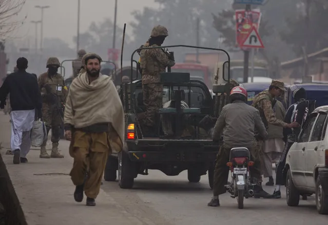 Pakistani army soldiers check vehicles near the Army Public School which was targeted by Taliban militants last year, in Peshawar, Pakistan, Monday, January 12, 2015. Children and staff returned to the school in northwestern Pakistan where Taliban gunmen nearly a month ago killed 150 people. (Photo by B.K. Bangash/AP Photo)