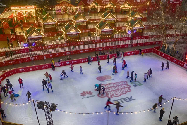 People skate on an ice rink in Kyiv, Ukraine, Wednesday, December 30, 2020. Despite COVID-19 quarantine restrictions, a lot of Ukrainians enjoyed outdoor Christmas events. (Photo by Efrem Lukatsky/AP Photo)