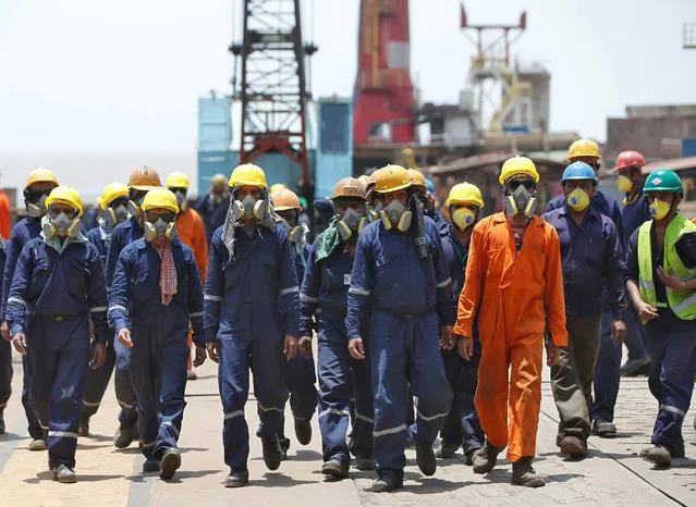 Workers wearing protective gear arrive to dismantle a decommissioned ship at the Alang shipyard in Gujarat, India, May 29, 2018. (Photo by Amit Dave/Reuters)