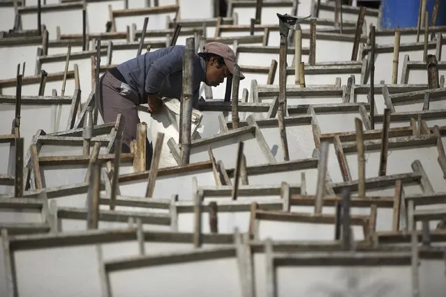 A man collects sheets of newly created handmade Nepali Lokta paper after they were left out to dry under the sun in Kathmandu January 7, 2015. (Photo by Navesh Chitrakar/Reuters)