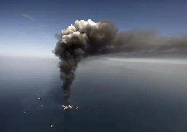 This April 21, 2010, file photo shows a large plume of smoke rising from BP's Deepwater Horizon offshore oil rig in the Gulf of Mexico. The film, “Deepwater Horizon” is stirring mixed emotions for family members of the 11 men who died in the blast. While their reactions to the movie vary, many relatives share a hope that the film will remind people about the disaster's human toll. (Photo by Gerald Herbert/AP Photo)