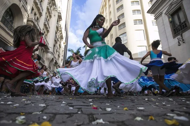 A woman dances during a rehearsal by the group “Tambores de Olokun” in Rio de Janeiro, Brazil, Sunday, April 17, 2022. The Brazilian municipalities of Rio de Janeiro and Sao Paulo postponed the traditional parades of the carnival samba schools to April 22 - 23, as a result of the COVID-19 pandemic. (Photo by Bruna Prado/AP Photo)