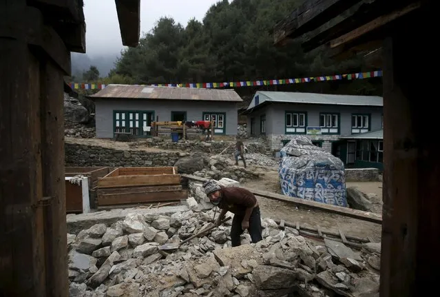 A man clears debris to rebuild a damaged lodge after the earthquake earlier this year in Solukhumbu district, also known as the Everest region, in this picture taken November 28, 2015. (Photo by Navesh Chitrakar/Reuters)