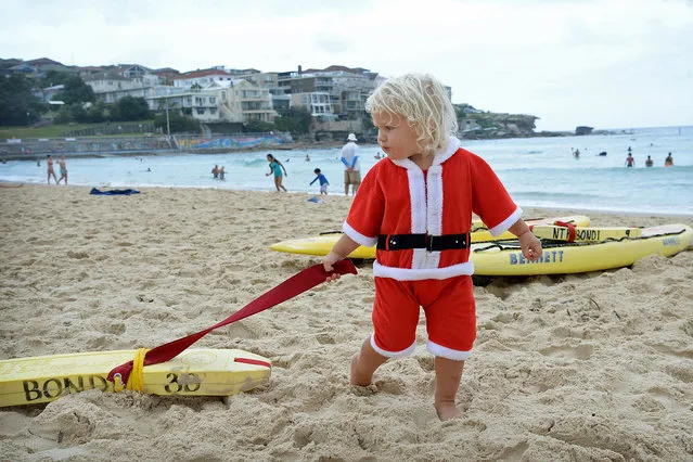 James Morgan, 2, plays on surfboards at Bondi beach in Sydney, Australia, 25 December 2013. Sydney-siders celebrated Christmas Day under wet and cloudy, but warm conditions. (Photo by Dan Himbrechts/EPA)