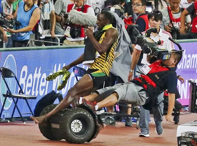 Usain Bolt of Jamaica is hit by a cameraman on a Segway as he celebrates after winning the men's 200 metres final at the 15th IAAF World Championships at the National Stadium in Beijing, China, August 27, 2015. (Photo by Reuters/Stringer)