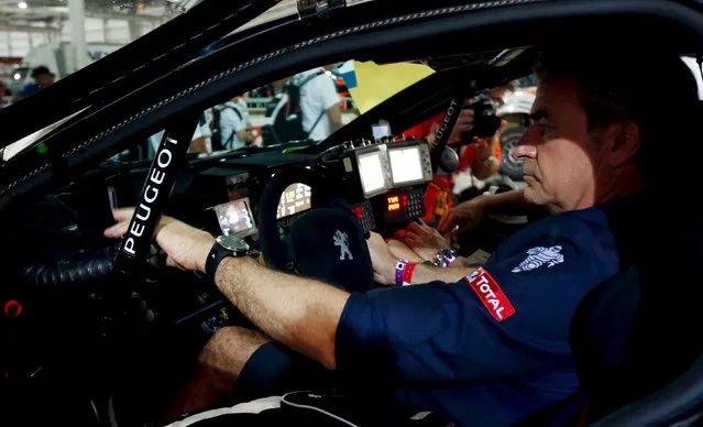 Peugeot driver Carlos Sainz of Spain sits inside his car at the technical verification area ahead of the Dakar Rally 2016 in Buenos Aires, Argentina, January 1, 2016. (Photo by Marcos Brindicci/Reuters)