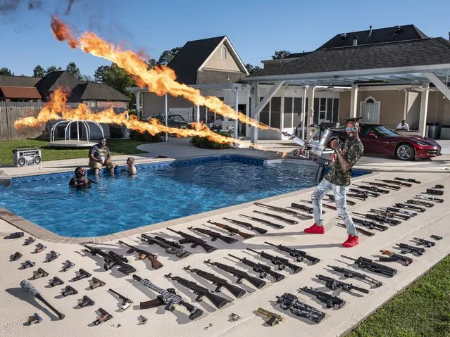 In this image released by World Press Photo, Thursday April 15, 2021, by Gabriele Galimberti for National Geographic, part of a series titled The “Ameriguns” which won first prize in the Portraits Stories category, shows Torrell Jasper (35) poses with his firearms in the backyard of his house in Schriever, Louisiana, USA, on April 14, 2019. A former US Marine, he learned to shoot from his father as a child. (Photo by Gabriele Galimberti for National Geographic, World Press Photo via AP Photo)