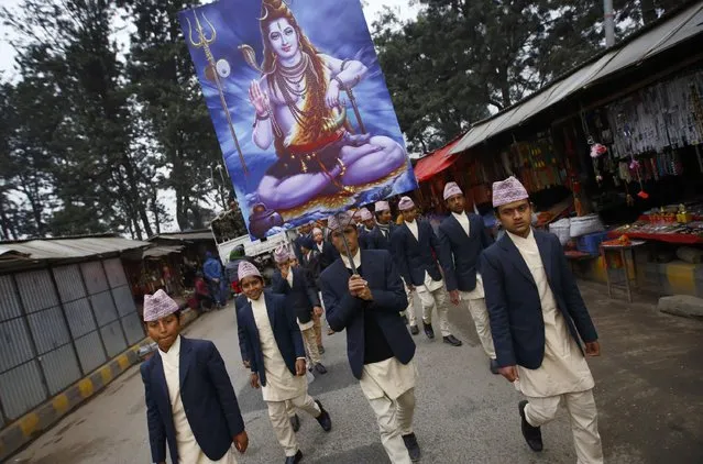 A youth holding a portrait of Lord Shiva takes part in a religious rally on the premises of Pashupatinath Temple in Kathmandu February 15, 2015. (Photo by Navesh Chitrakar/Reuters)