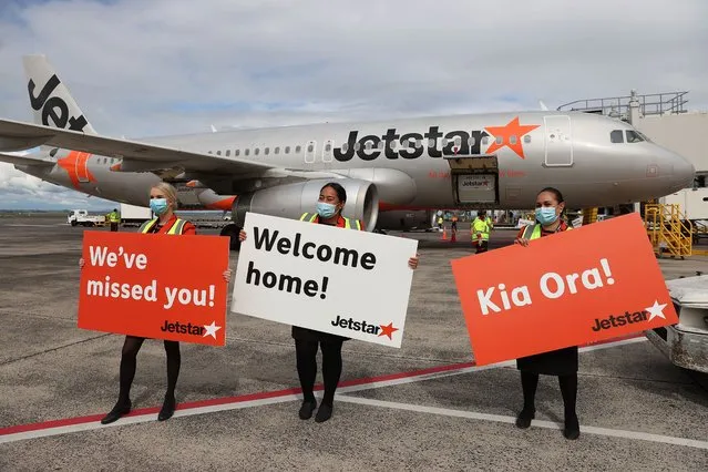 Staff welcome the first quarrantine free trans-tasman flight to Auckland from Sydney on April 19, 2021 in Auckland, New Zealand. The trans-Tasman travel bubble between New Zealand and Australia begins on Monday, with people able to travel between the two countries without needing to quarantine. (Photo by Fiona Goodall/Getty Images)