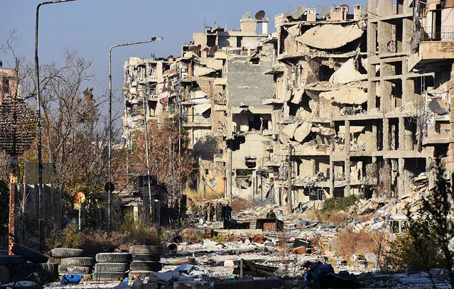 Destruction is seen in Aleppo's Bustan al-Basha neighbourhood on November 28, 2016, during Syrian pro-government forces assault to retake the entire northern city from rebel fighters. Government forces have retaken a third of rebel-held territory in Aleppo, forcing nearly 10,000 civilians to flee as they pressed their offensive to retake Syria's second city. In a major breakthrough in the push to retake the whole city, regime forces captured six rebel-held districts of eastern Aleppo over the weekend, including Masaken Hanano, the biggest of those in eastern Aleppo. (Photo by George Ourfalian/AFP Photo)