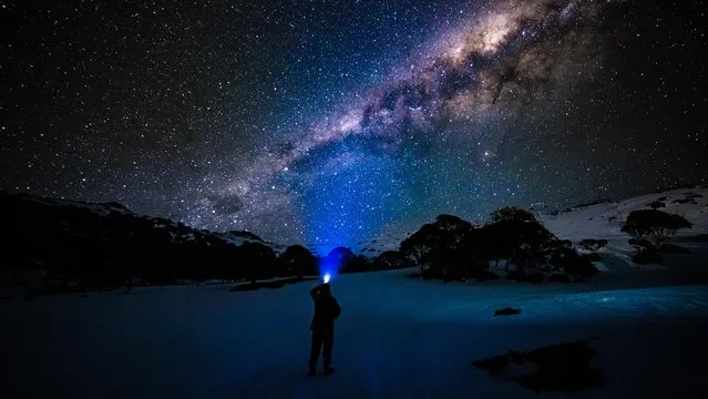 A person shines a torch into the night sky on the ski fields on September 14, 2020 in Charlotte Pass, Australia. Visitors to the Charlotte Pass ski resort have been enjoying spring snow conditions, with the ski season expected to continue until 4 October 2020. Charlotte Pass has an elevation of 1837 metres and has escaped some of the higher temperatures in lower resorts which has the snow melting earlier than others. (Photo by Bill Blair#JM/Getty Images)