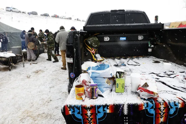 A group of veterans gather to eat as snow falls inside of the Oceti Sakowin camp as “water protectors” continue to demonstrate against plans to pass the Dakota Access pipeline adjacent to the Standing Rock Indian Reservation, near Cannon Ball, North Dakota, U.S. December 5, 2016. (Photo by Lucas Jackson/Reuters)