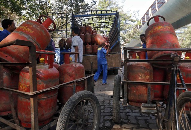 Workers load liquefied petroleum gas (LPG) cooking cylinders onto a supply truck outside a distribution centre in Mumbai in this February 19, 2015 file photo. India may slash its food and fuel subsidy bill by about $8 billion in next week's budget, two sources said. (Photo by Shailesh Andrade/Reuters)
