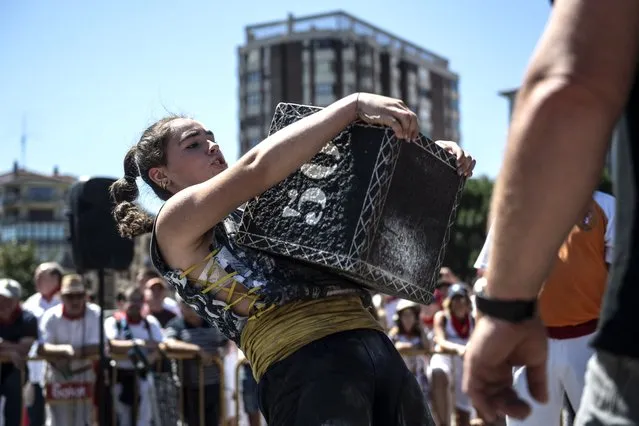 Basque “Harrijasotzaile” stone lifter Udane Ostolaza lifts a stone during the San Fermin Festival in Pamplona, northern Spain on July 10, 2022. (Photo by Ander Gillenea/AFP Photo)