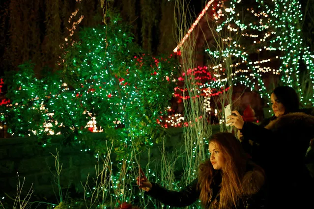 People take photos at the Dyker Heights Christmas Lights in the Dyker Heights neighborhood of Brooklyn, New York City, U.S., December 23, 2016. (Photo by Andrew Kelly/Reuters)