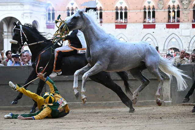 Italian jockey Stefano Piras, who races for the “Bruco” district, falls during a false start of his horse “Uragano Rosso” during the historical Italian horse race Palio di Siena, in Siena, Italy, 02 July 2022. After two years of stop for the pandemic, it was won by the “Dragon” district. The traditional horse races between the Siena city districts will be held 02 July as the “Palio di Provenzano” on the holiday of the Madonna of Provenzano and on 16 August as the “Palio dell'Assunta” on the holiday of the Virgin Mary. (Photo by Claudio Giovannini/EPA/EFE)