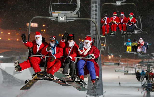 Skiers and snowboarders dressed as Ded Moroz, Russian equivalent of Santa Claus, and Snegurocka (Snow Maiden) ride a lift uphill during the Ded Moroz and Snegurochka Night to mark the upcoming New Year celebration at the Bobrovy Log ski resort in the suburbs of Krasnoyarsk, Siberia, Russia December 29, 2016. (Photo by Ilya Naymushin/Reuters)