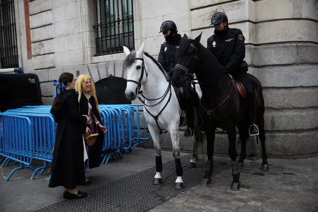 Revellers talk to police officers on horseback at Puerta del Sol square ahead of New Year's celebrations in central Madrid, Spain, December 31, 2016. (Photo by Susana Vera/Reuters)