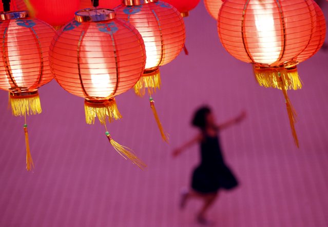 A child plays beneath lanterns at a temple decorated to celebrate the Chinese New Year in Kuala Lumpur, Malaysia, February 7, 2016. (Photo by Olivia Harris/Reuters)