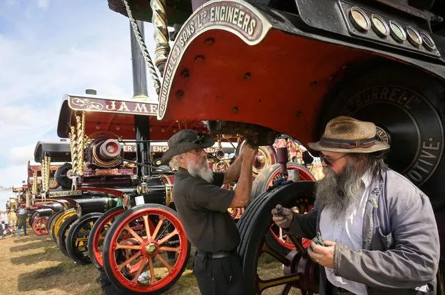 Exhibitors clean their steam road locomotive engine at the Great Dorset Steam Fair, on August 28, 2022 in Blandford Forum, England. First held in 1969 and reputedly the largest collection of steam and vintage equipment to be seen anywhere, it regularly attracts 200,000 visitors to the site to see steam road locomotive, as well as other vintage vehicles. (Photo by Finnbarr Webster/Getty Images)