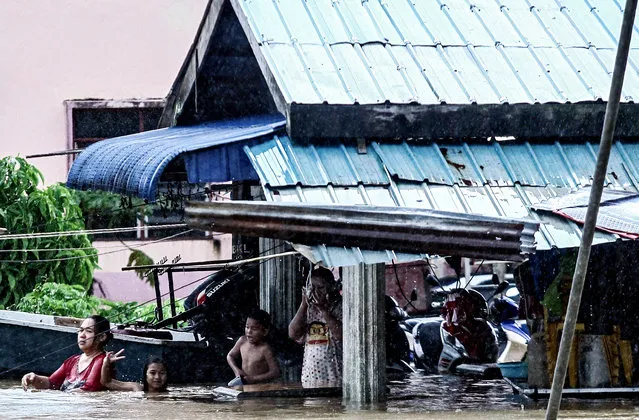 Residents wade in floodwaters outside their home in Malaysia's northeastern town of Rantau Panjang, which borders Thailand, on January 3, 2017. Emergency services in Malaysia deployed boats and trucks on January 3, as thousands of villagers were stranded after four days of heavy rain caused flooding in east coast states, officials said. (Photo by AFP Photo/Stringer)