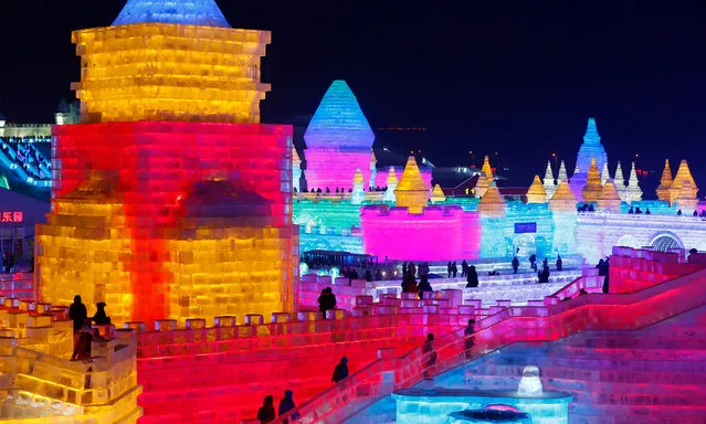 People visit the ice sculptures illuminated by coloured lights at Harbin ice and snow world for the 33rd Harbin International Ice and Snow Festival in Harbin city, China's northern Heilongjiang province, 05 January 2017. (Photo by Wu Hong/EPA)